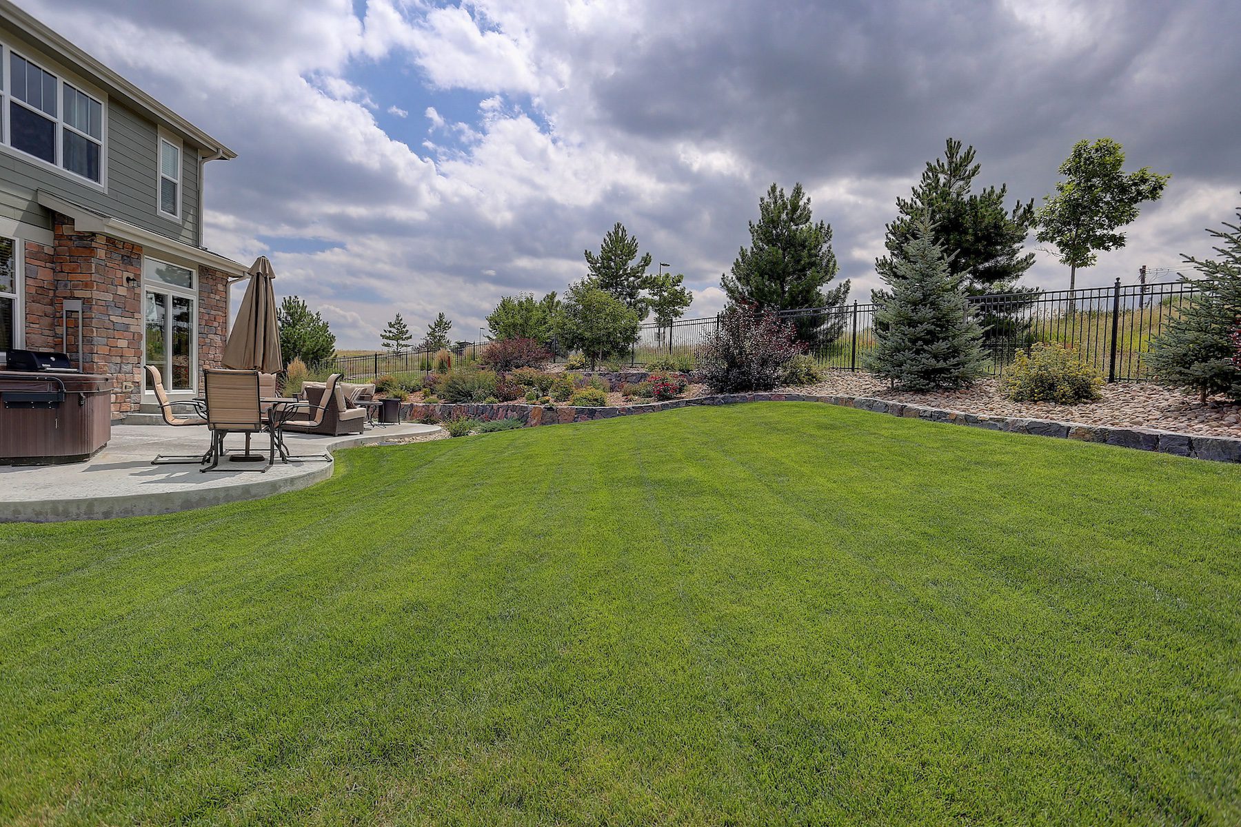 Suburban home with large green lawn and drought-tolerant xeriscaping mansfield-tx-lawn-care.jpeg